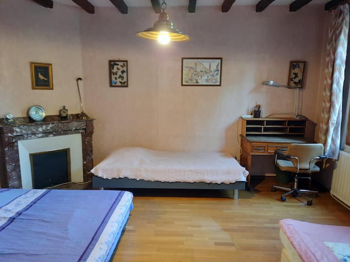 En esta habitación en la planta baja hay una cama doble, dos camas individuales y un escritorio.