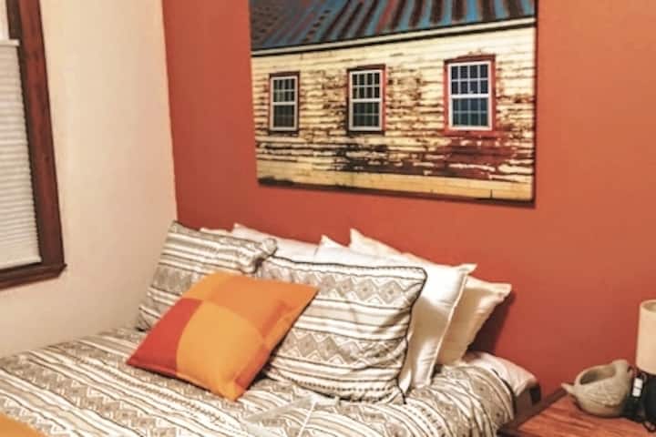 Our second bedroom faces out towards the back garden.  Yes, it's a vibrant burnt orange wall.  That picture is an original photograph of an old barn from Dufur, Oregon.