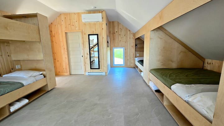 2 queens bed in een pod met intrekbare gordijnen om intimiteit te behouden.  Een stapelbed met eenpersoonsmatras.