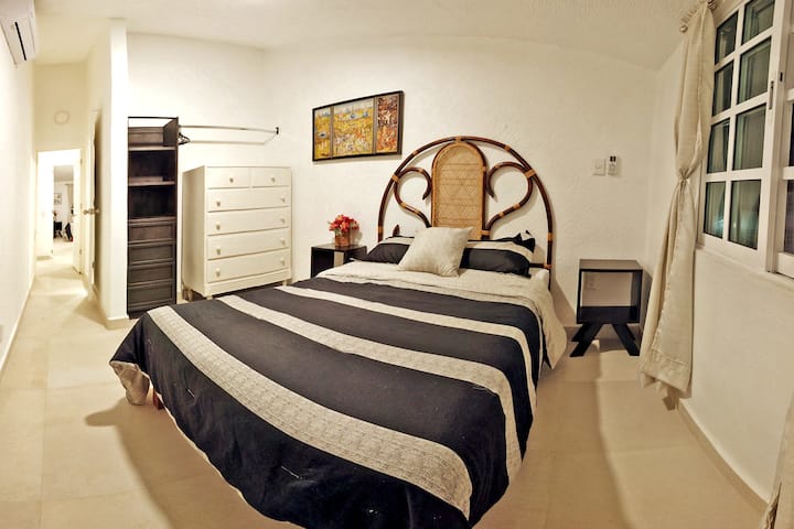 Dhomë gjumi kryesore me krevat dopio, ajër të kondicionuar, banjë private dhe tarracë.