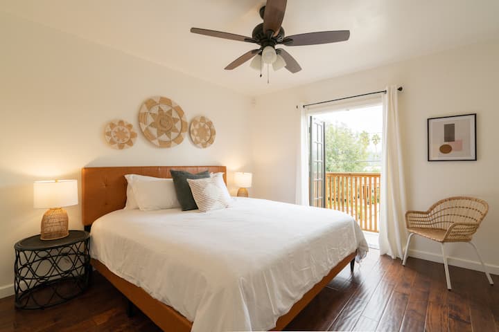 通风良好的主卧室设有阳光明媚的阳台和豪华加大双人床