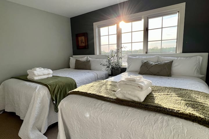 BR #4 is located upstairs adjacent to one of the full bathrooms.  It includes two queen sized beds, a bedside stool with cozy greenery, a full closet and amazing sunsets.