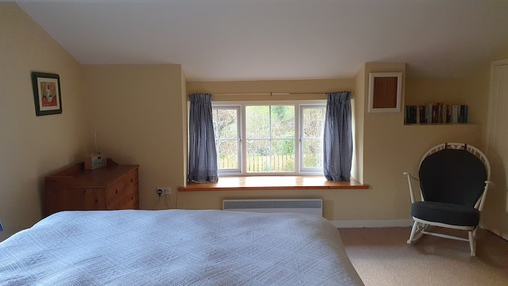 El dormitorio principal, luminoso y espacioso, con vistas al jardín. 