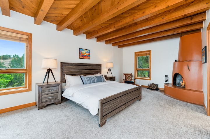 The primary bedroom with king bed, private bath, private patio and wood burning kiva fireplace.