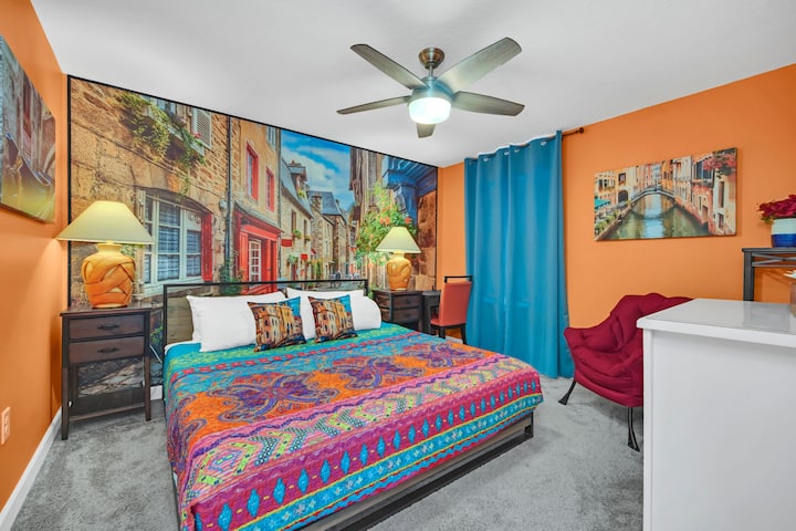 BR3 Mediterranean Town King: historical houses, cobbled street, blue gondola, city canal. Bed with award-winning firm mattress, water view, TV, ceiling fan,  desk/chair, fabric large lazy chair, , attached bathroom (BA3) shared with Frozen bedroom. 