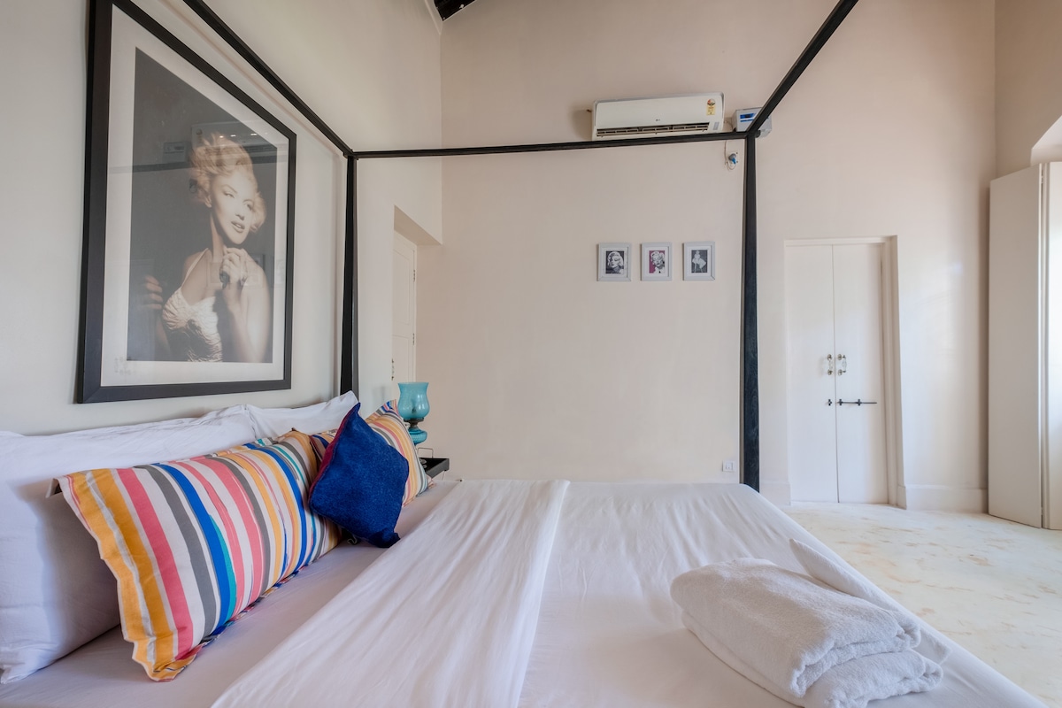 With two big windows & plenty of natural light, this room has a grand four-poster bed & classy aesthetics. 