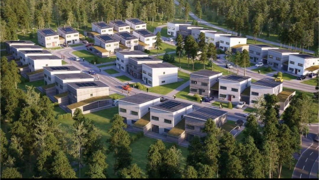 Aerial view of a modern residential community is visible, featuring several contemporary homes with flat roofs. The buildings are arranged in a structured manner within a green landscape, characterized by trees and well-maintained pathways, emphasizing the proximity to nature.