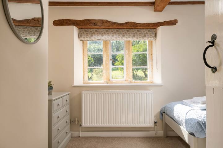 Bedroom 2

Bedroom 2 features a striking Cotswold stone wall and an original stone mullion window that overlooks the garden. 