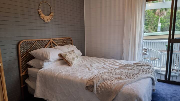 Bedroom 2:  The coastal themed queen bedroom on the upper floor  offers a cute balcony draped in nature.