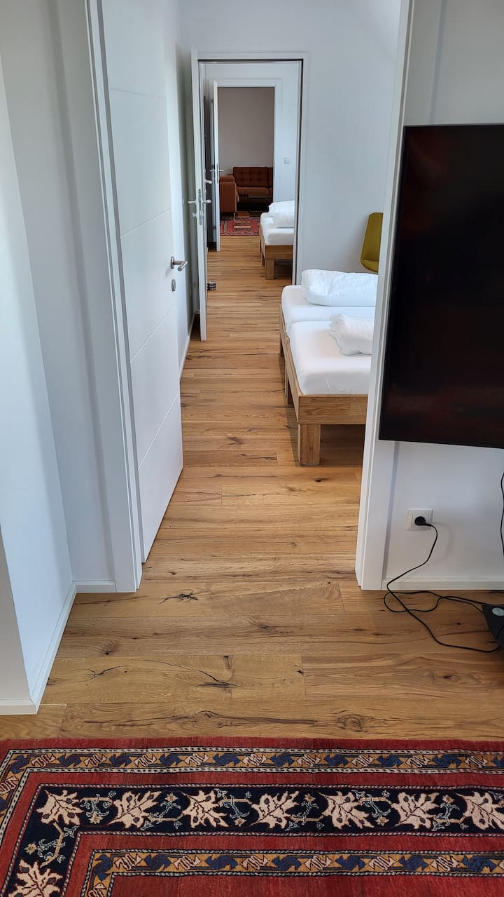 Uitzicht vanuit de woonkamer naar de woonkamer met nieuw geïnstalleerde tussendeuren. De tussendeuren kunnen aan beide kanten worden gesloten.