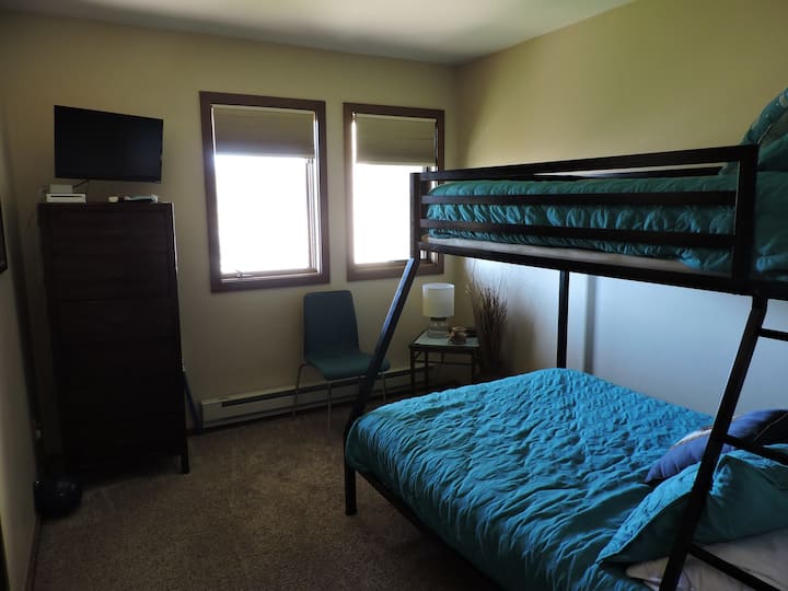 Долна спалня 2 с двуетажни легла и телевизор.