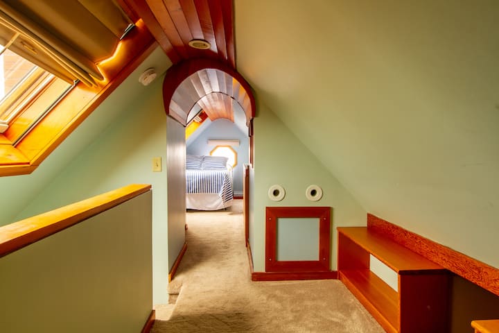 Loft bedroom - Full size bed, sleeps 2. Dreamy, nautical room - complete with porthole window and skylights. Kids play area in the foreground.