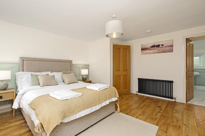 Chumba hiki cha ukubwa wa mfalme kiko kwenye ghorofa ya pili. Ni tulivu sana na ina sehemu yake ya ndani. Pia inajumuisha televisheni na meza ya kuvaa. 