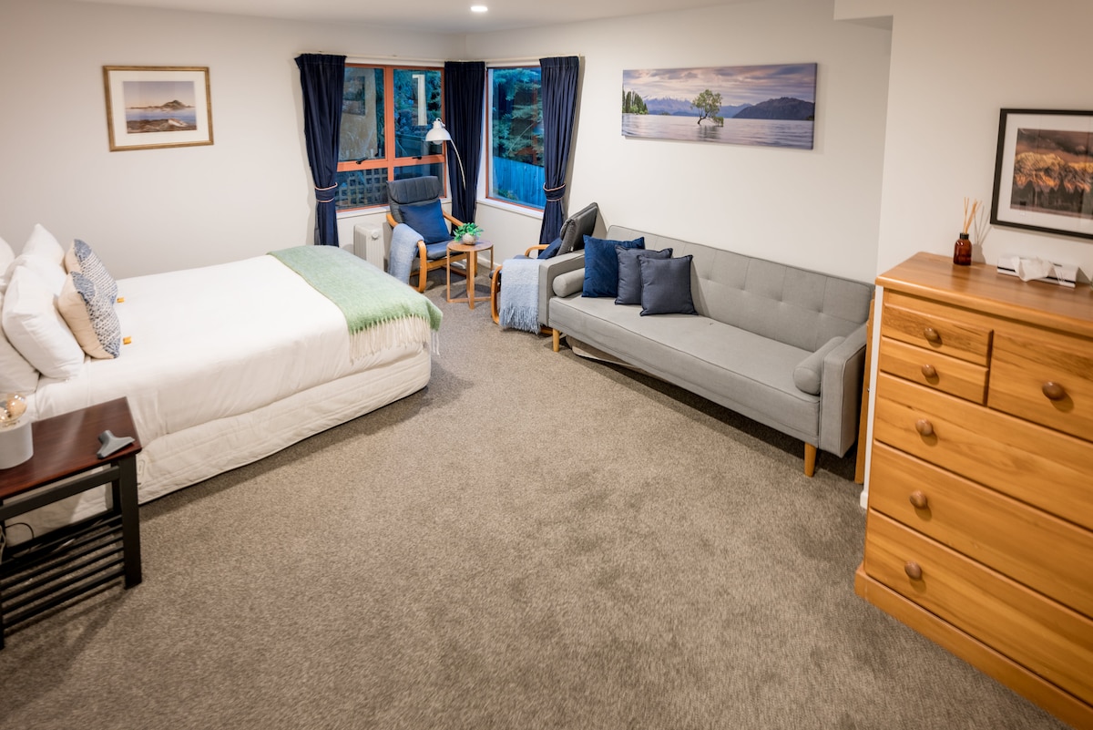 חדר שינה שני ענק עם ספה, אזור קפה/פינת עבודה ונוף לאגם