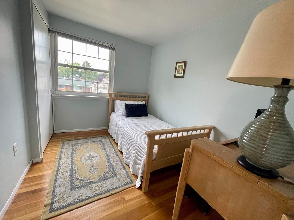 غرفة نوم بسرير بمقاس مزدوج وخزانة ومكتب يقع في الطابق العلوي