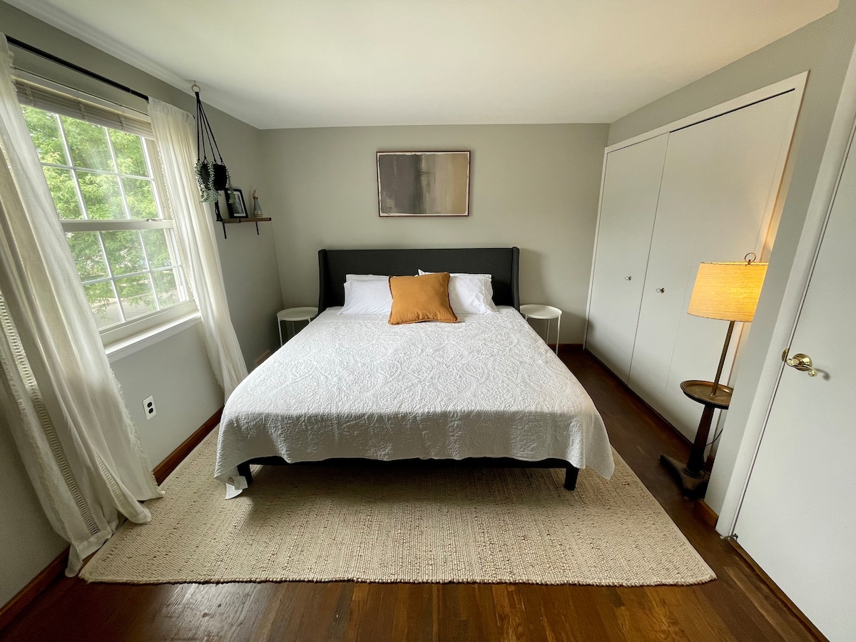 غرفة نوم أساسية تقع في الطابق العلوي مع سرير بمقاس كبير وخزانة ملابس كبيرة ومكتب قابل للتعديل لتلبية أي احتياجات عمل