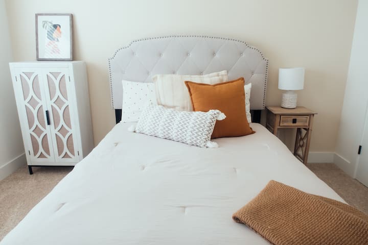 El dormitorio 3 se encuentra arriba con el dormitorio 2, el baño 2 y el espacio de estar adicional. ¡Cama tamaño queen con ropa de cama moderna y neutra! 