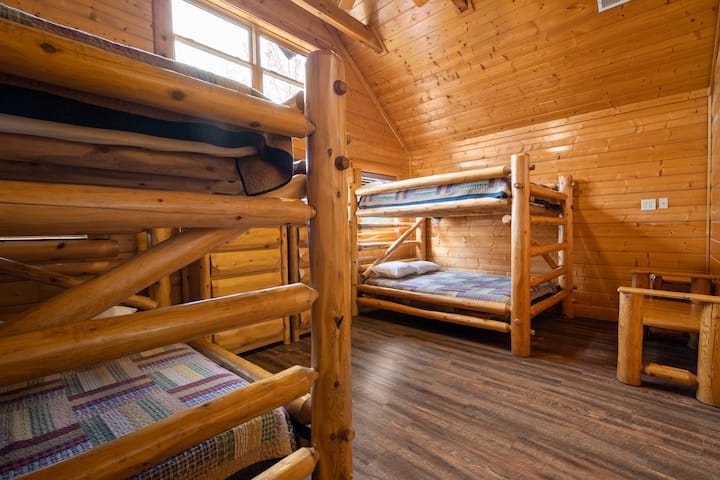 غرفة النوم في الطابق العلوي: هذه واحدة من ثلاث غرف نوم بطابقين تحتوي على (2) مجموعات من الملكة على أسرّة بطابقين بحجم كوين. يأتي مجهزًا بتلفزيون ذكي خاص به وحمامه الخاص.