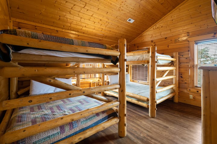 غرفة النوم في الطابق العلوي: هذه واحدة من ثلاث غرف نوم بطابقين تحتوي على (2) مجموعات من الملكة على أسرّة بطابقين بحجم كوين. يأتي مجهزًا بتلفزيون ذكي خاص به وحمامه الخاص.