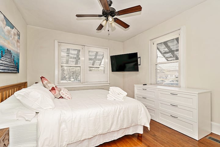Spacious bedroom with king-size bed and large 60-inch smart TV