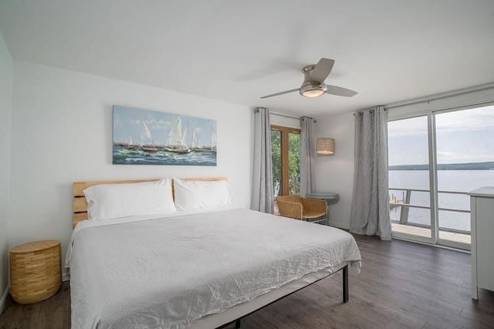 Kingslaapkamer op de tweede verdieping met uitzicht op het meer. Word wakker bij zonsopgang of trek de gordijnen dicht en slaap uit! 