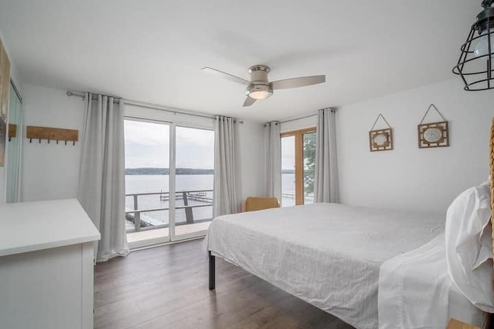 Kingslaapkamer op de tweede verdieping met uitzicht op het meer. Word wakker bij zonsopgang of trek de gordijnen dicht en slaap uit! 