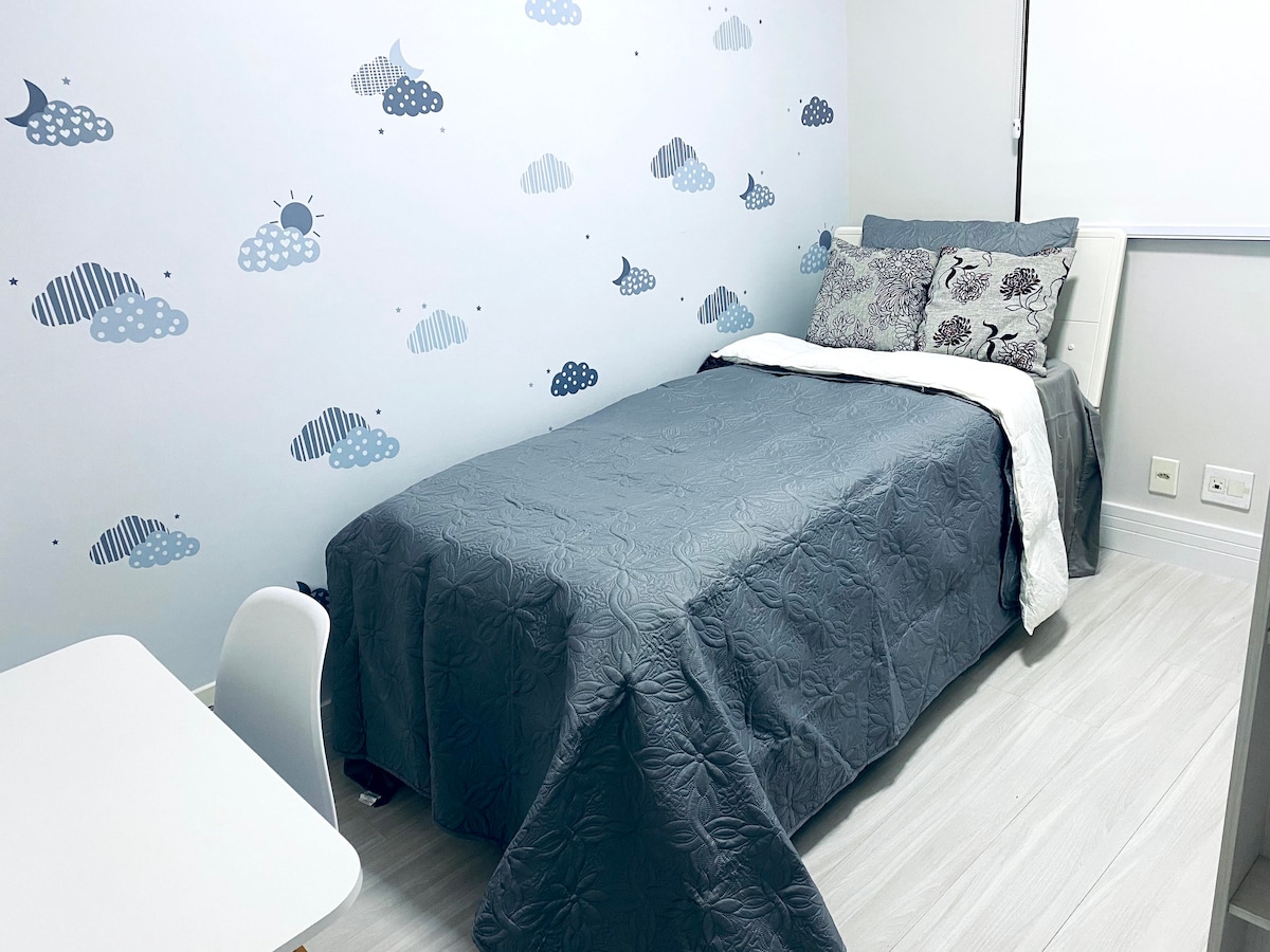 חדר שינה, מיטת יחיד, מיטת עזר ושולחן עבודה עם כיסא עבודה