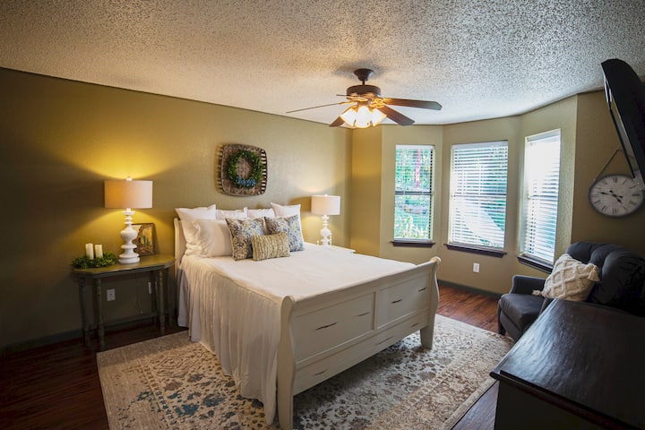 Queen size master bedroom with bay window to views of outdoor gardens.  A corner recliner for your reading and relaxation.