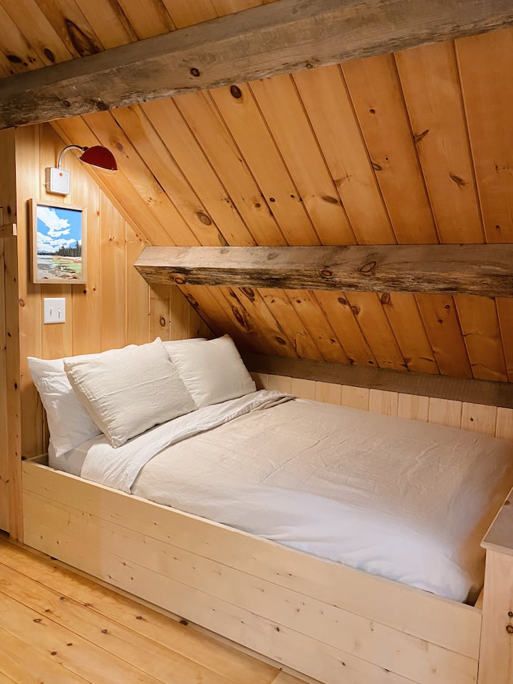 Krevat i kompletuar me shtroja, një dollap dhe hapësirë të shtuar për veshje në krye të shkallëve.