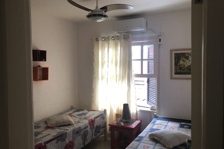 Dhoma 2 lart me dy krevate tek, ventilator, dollap dhe kondicioner. Pamja e pasme