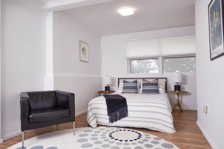 Una cama tamaño queen, una amplia ventana con vista al patio y persianas de total privacidad mejoran el dormitorio grande. Una silla de cuero permite un lugar cómodo para leer tu libro. 