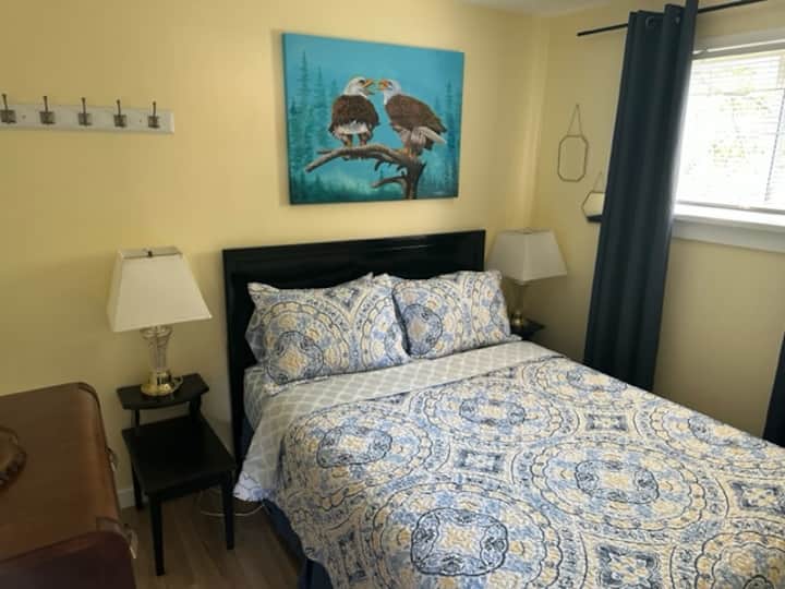 Cozy QHEEN SIZE BED with rge airy window, night tables and 2 lamps.
  Let fresh airy night breezes bring the country living indoors.