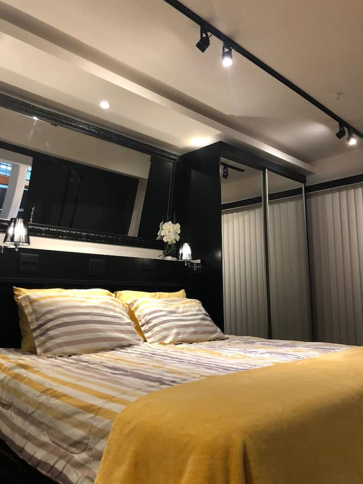 Luxusný loft (apartmán 1 z 3): manželská posteľ King v izbe, ktorá je v podkrovnom medziposchodí. Zrkadlové skrinky vo vysokom štandarde a veľké zrkadlo nad posteľou. 