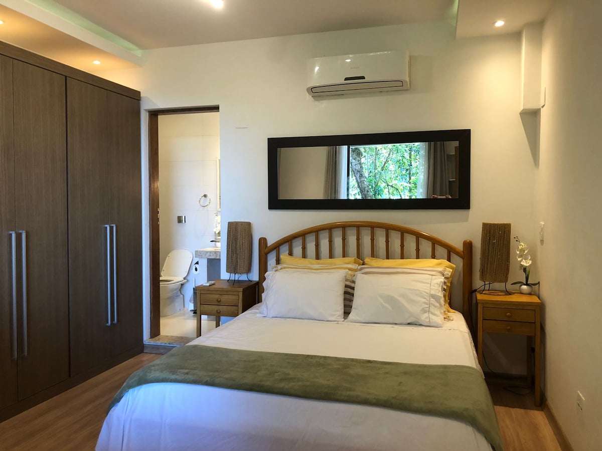 דירה מפוארת (דירה 3 מתוך 3): סוויטה עם מיטת קווין סייז, מלתחה גדולה וחדר רחצה משיש עם קופסה ברקע. המיטה משקיפה על היער בחזית.