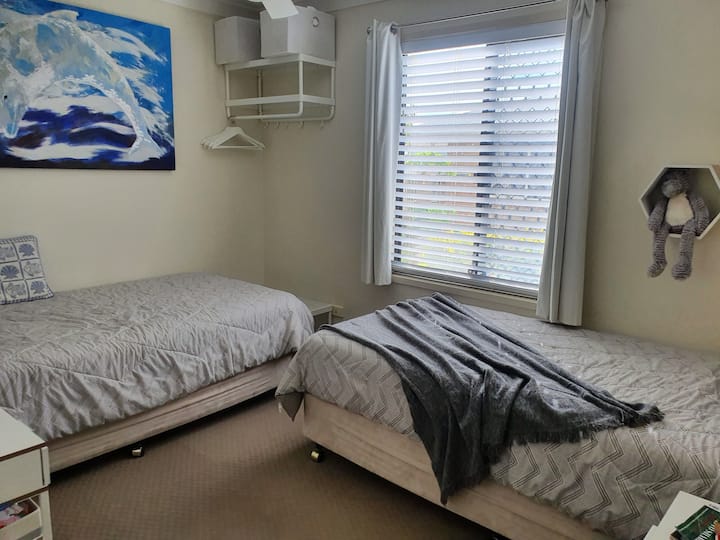 Bedroom 2 which has jumbo size single beds and ceiling fan.
