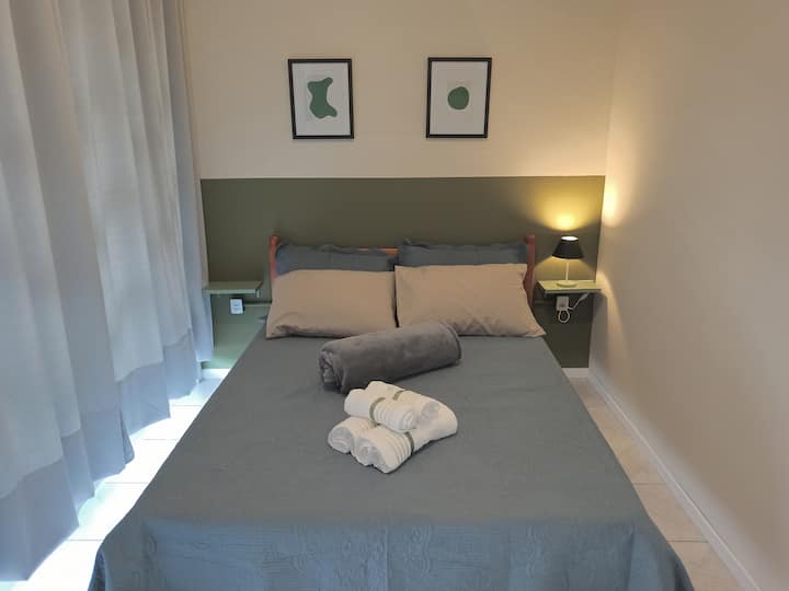 ห้องพักพร้อมเตียงคู่เครื่องปรับอากาศและพัดลมเพดานพร้อมทางไประเบียง