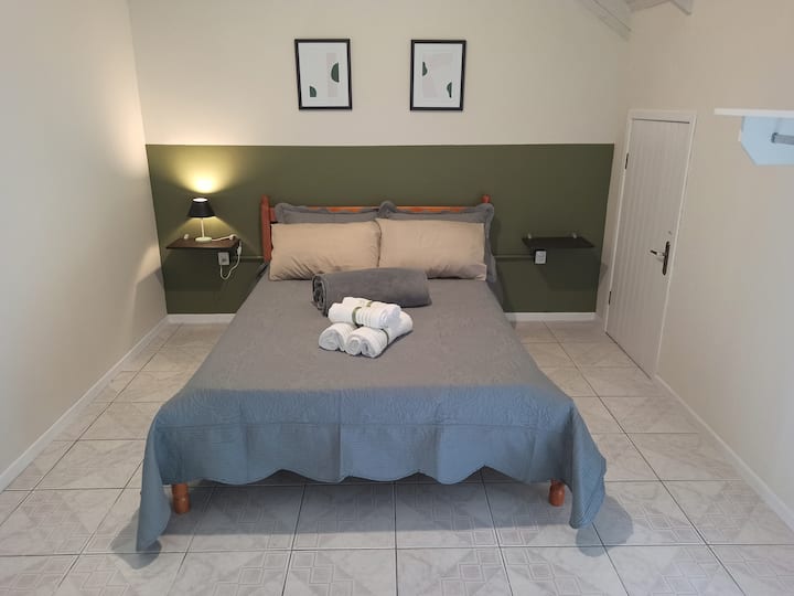 ห้องพักพร้อมเตียงคู่พัดลมเพดานและทางไประเบียง