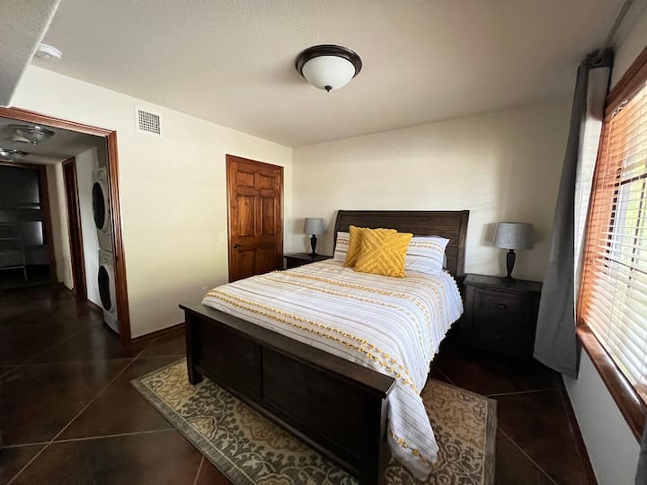Dormitorio queen en la planta baja ubicado fuera de la sala de estar y junto al baño de tamaño completo en la planta baja.