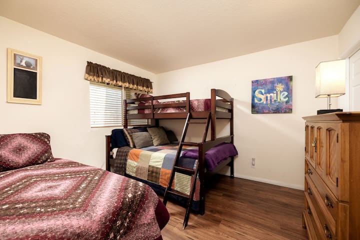 Seconda camera da letto al piano inferiore con letto a due piazze,  Twin su letti a castello completi e abat-jour con porte usb per una ricarica facile del telefono.