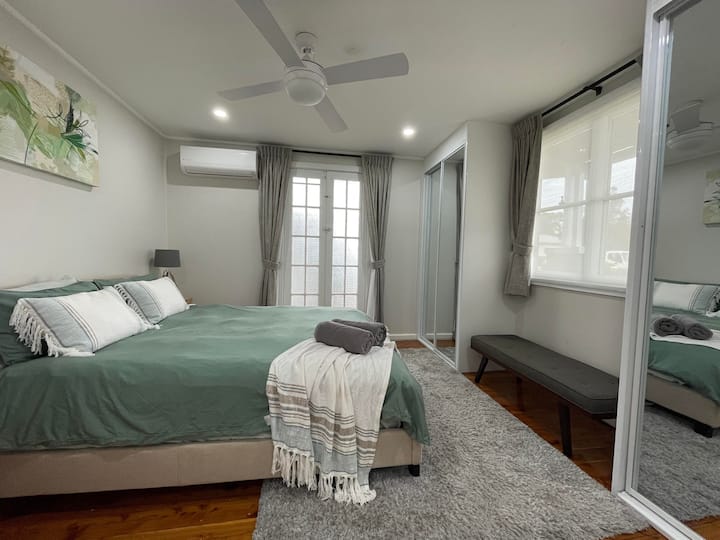 Chumba cha kulala cha pili kilicho na kitanda cha ukubwa wa malkia, feni ya dari, kiyoyozi cha mzunguko wa nyuma, vigae vilivyojengwa ndani, na ufikiaji wa veranda ya mbele. Madirisha ya mbele pia yana glasi nene ili kusaidia kupunguza kelele.