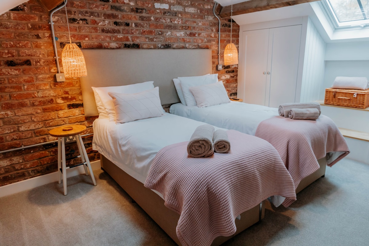 Втората спалня е разположена в стрехите срещу красивата открита тухлена стена...