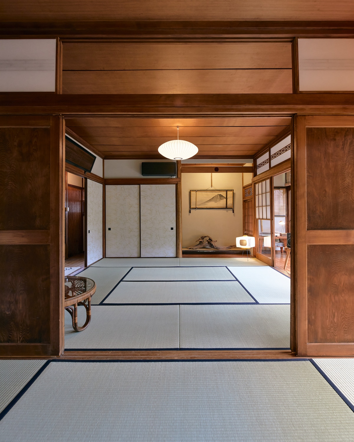 View of the 8 mat tatami room from the 6 mat tatami room. The rooms are separated by sliding wood doors
