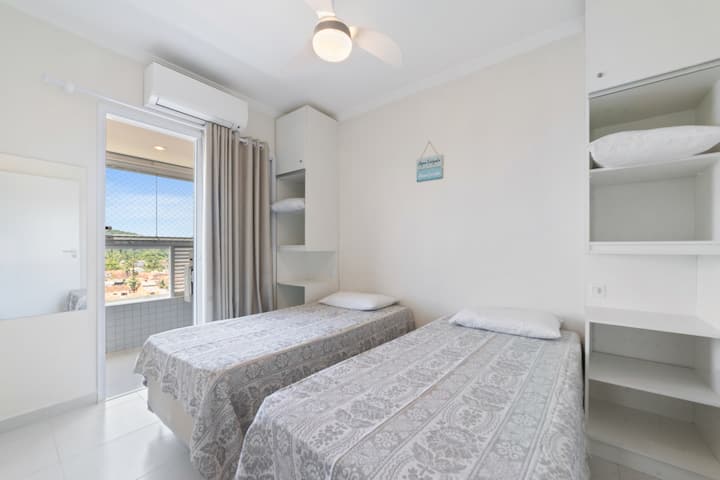 Dhomë gjumi me dy krevate tekë dhe dalje në ballkon, perde errësuese, me ajër të kondicionuar ose ventilator tavani.