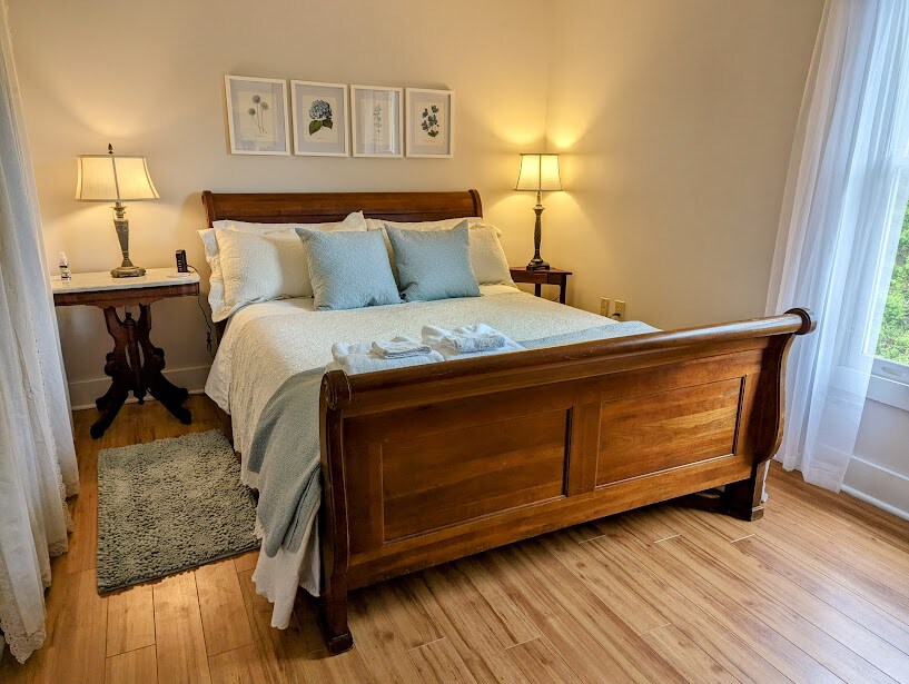 Main bedroom features queen-sized bed.

Your reservation reserves the ENTIRE home (main home AND attached guest suite). Each has its own living and dining areas, bedroom with queen bed & full bath. Sunroom provides futon (full-size bed) and 1/2 bath.