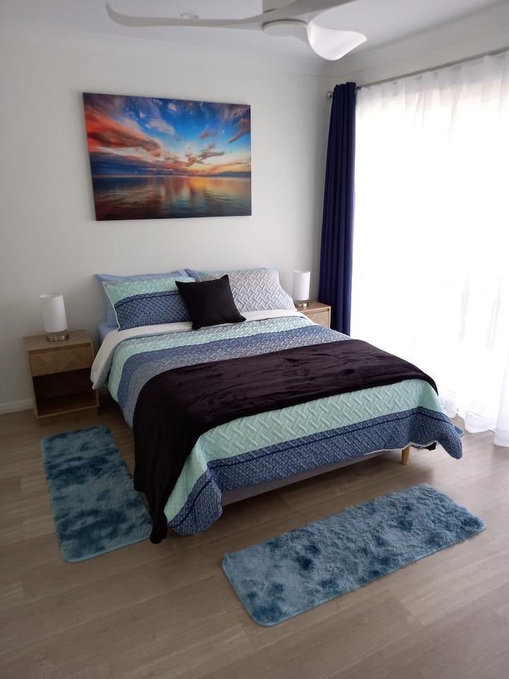 2e slaapkamer met een tweepersoonsbed. Een klein balkon van deze slaapkamer.