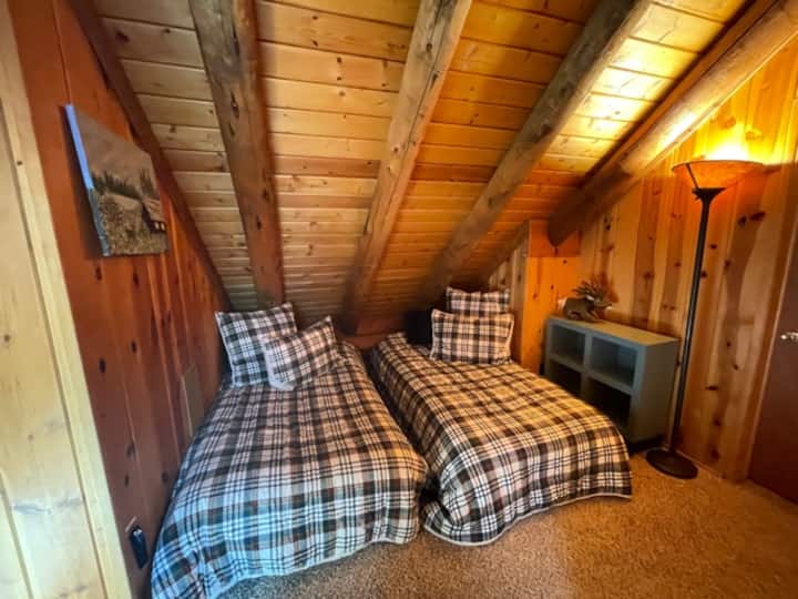 غرفة علوية تضم سريرين صغيرين