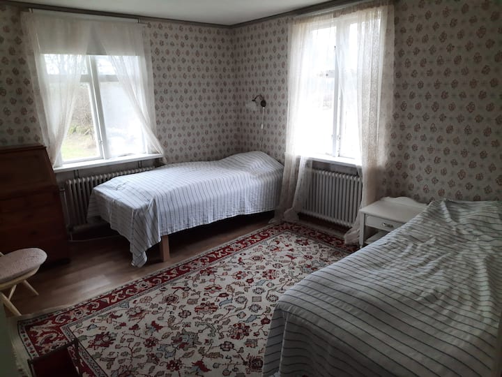 Dhomë gjumi me dy krevate tek dhe një sekretare që mund të përdoret si tavolinë.