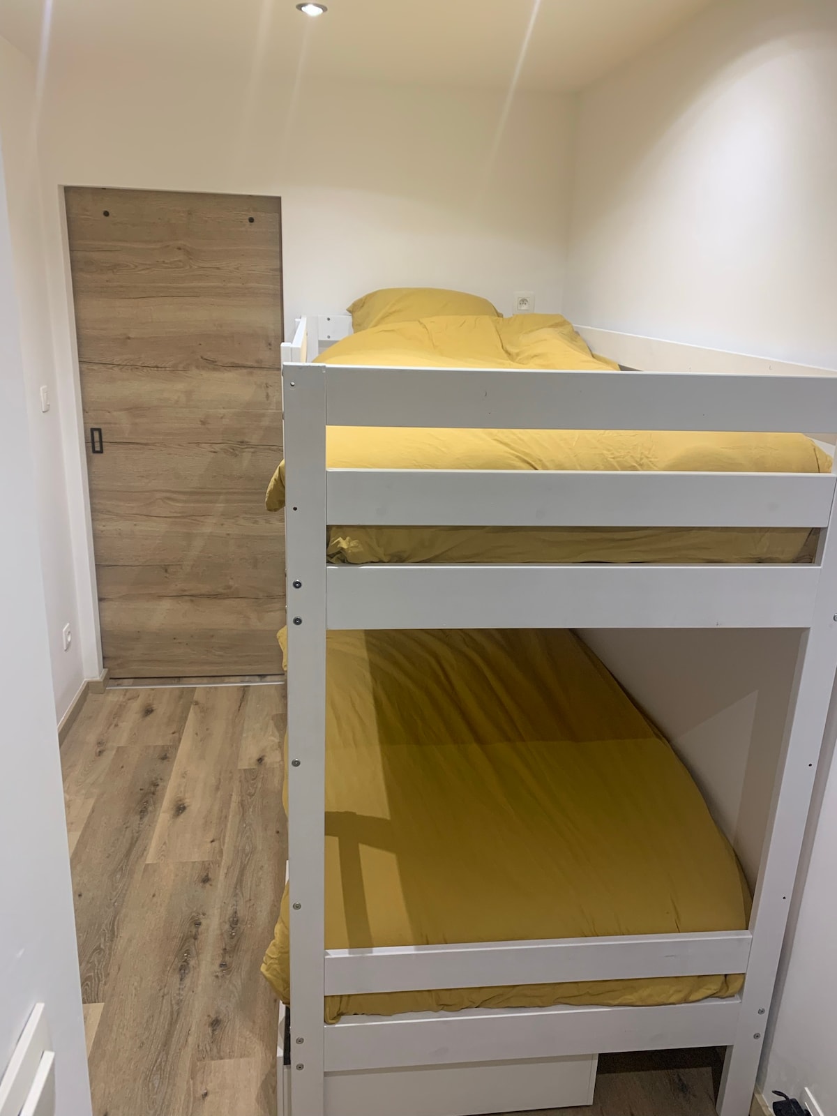 Drveni kreveti na kat s prostorom za odlaganje u nastavku. Sigurnosni barovi na gornjem krevetu. 