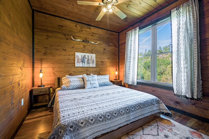 غرفة نوم بسرير كينج في الطابق الرئيسي، ومصابيح بجانب السرير مجهزة بمنافذ يو إس بي لشحن أجهزتك! تحتوي كل غرفة نوم على تلفزيون ذكي أيضًا.