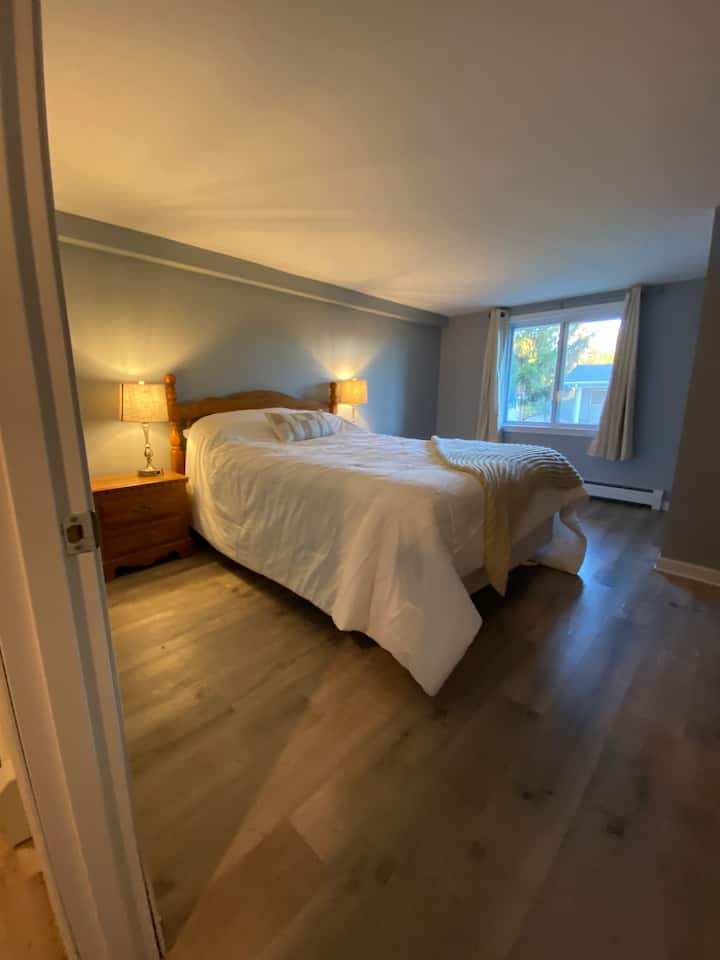 Dhomë gjumi në bodrum #3 Tan dhe krevat dopio gri dhe fustan i madh me pasqyrë